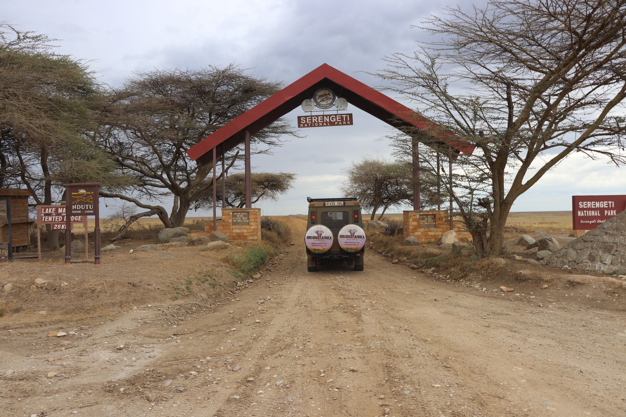 An Enclose Africa Safaris Land Cruiser driving through the Serengeti National Park entrance gate, Tanzania